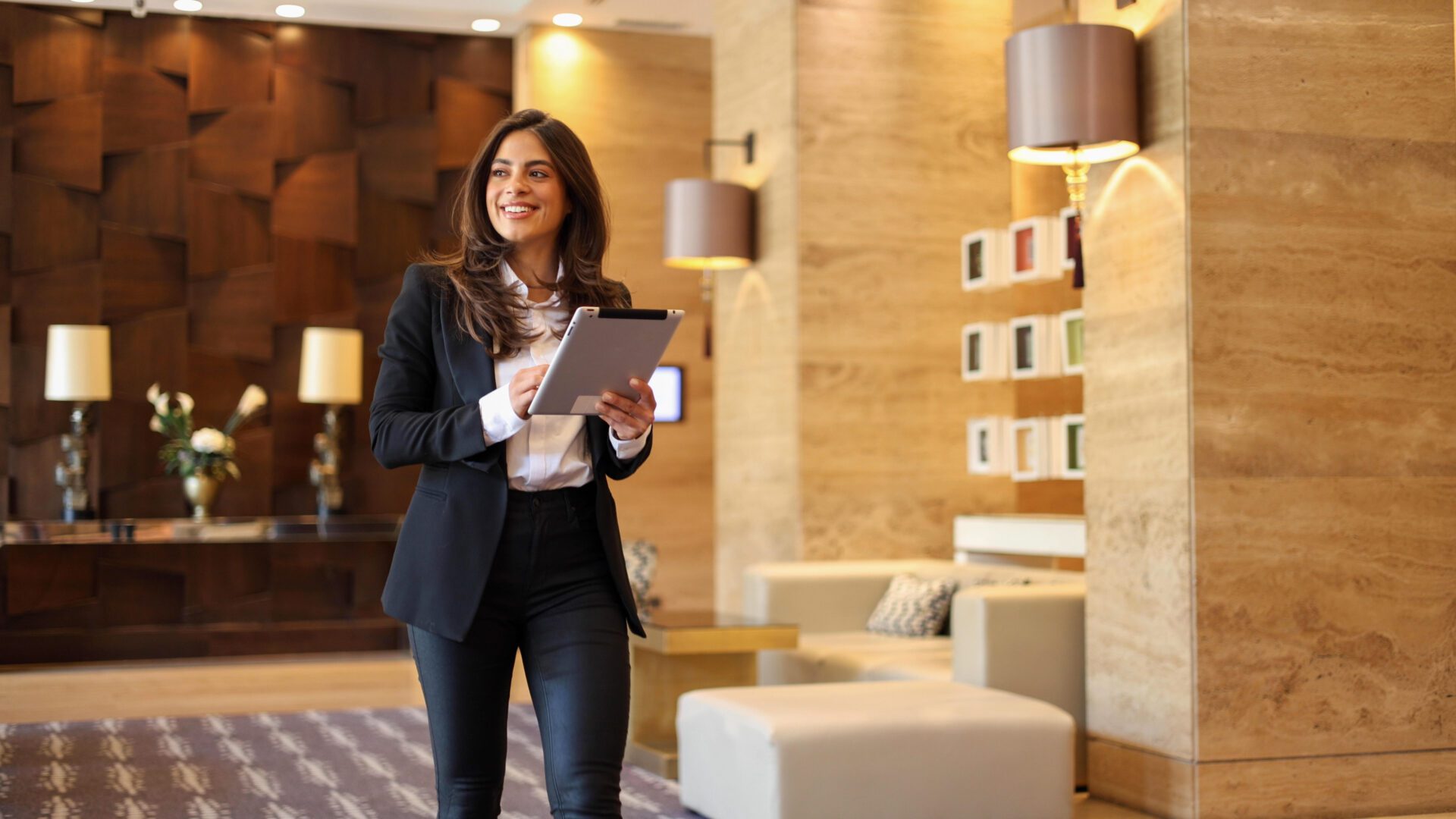 Businesswoman smiling with tablet in lobby