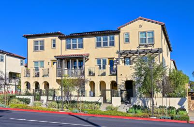 Modern three-story apartment building with balconies and arched entrances.