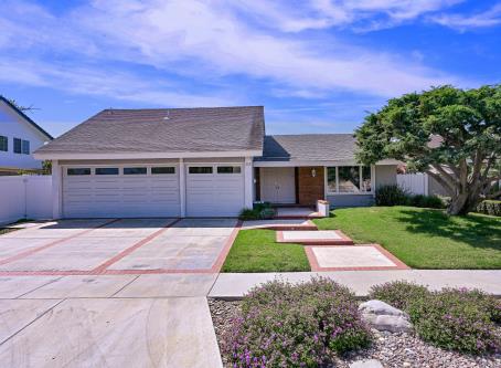 Single-story suburban home with a spacious driveway and well-maintained lawn.