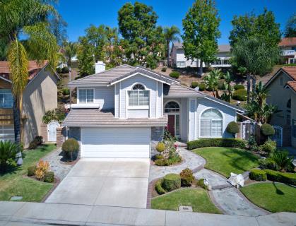 A modern two-story house with a well-kept front yard and driveway.