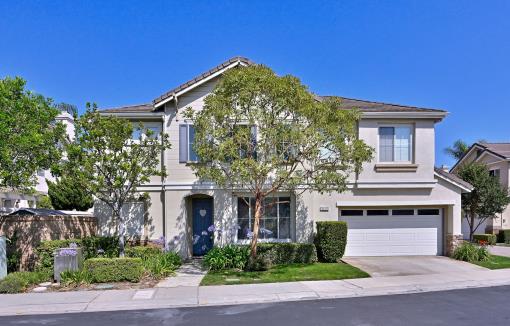 Modern two-story house with beige exterior and attached garage.