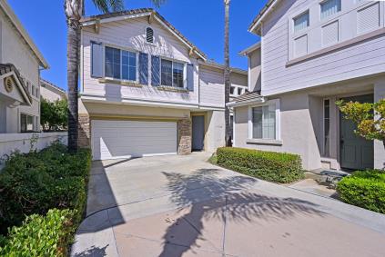 Modern two-story house with a double garage and sunny driveway.