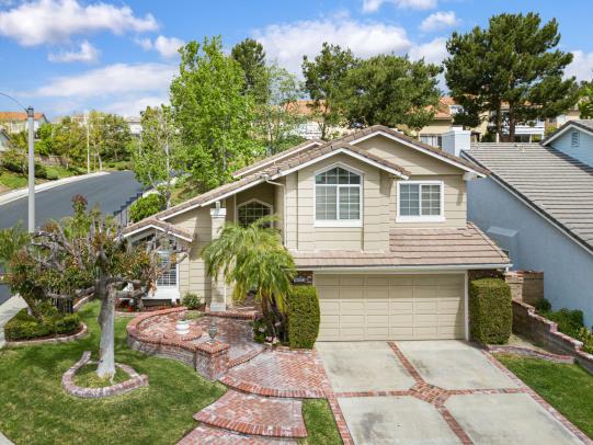 A charming suburban house with a well-maintained front yard and driveway.