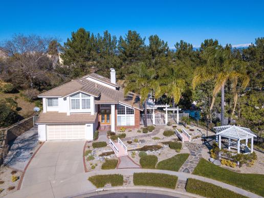 Spacious suburban home with a well-maintained yard and clear blue sky.