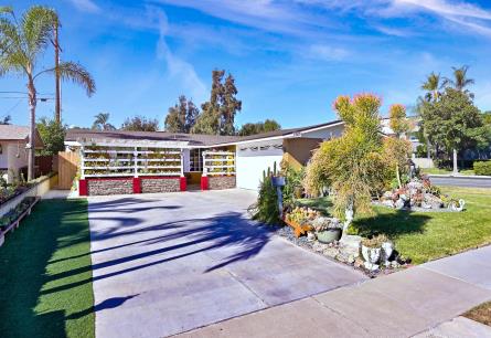 Mid-century modern house with a spacious driveway and desert landscaping.