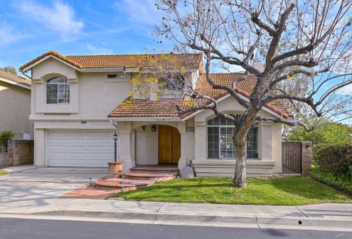 A two-story suburban house with a tree in front and a two-car garage.