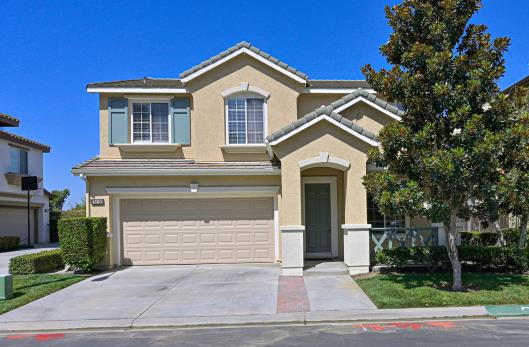 Modern two-story house with a garage and a clear blue sky.