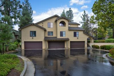 Modern three-car garage house on a rainy day.