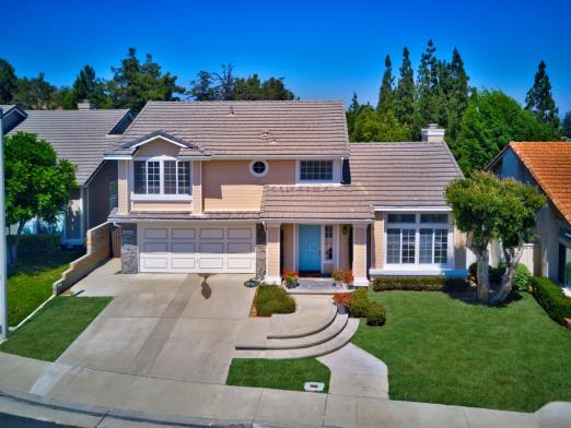 Spacious modern house with a manicured lawn and clear blue sky.