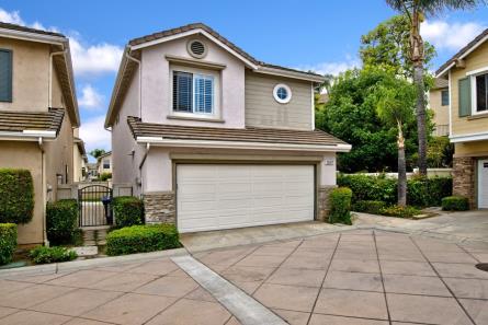 Modern two-story house with a double garage and beige exterior.