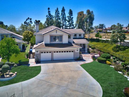 Spacious suburban house with a large driveway and well-maintained lawn.