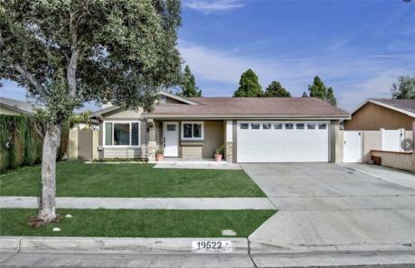 Single-story suburban house with a two-car garage and well-kept lawn.