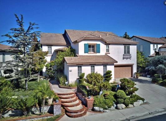 Elegant two-story house with manicured garden and curved staircase.