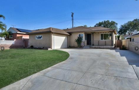 Single-story house with a two-car garage and well-kept lawn.
