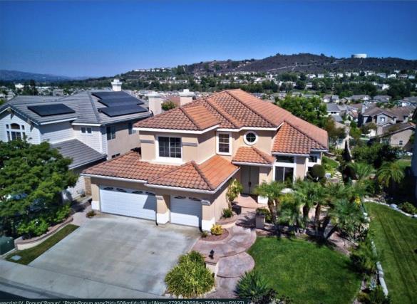 Spacious suburban house with terracotta roof and three-car garage.