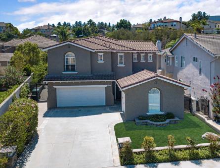 Modern two-story house with a spacious driveway and landscaped front yard.