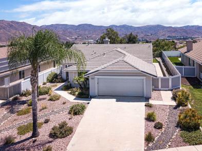 Single-story house with a desert landscape and mountain backdrop.
