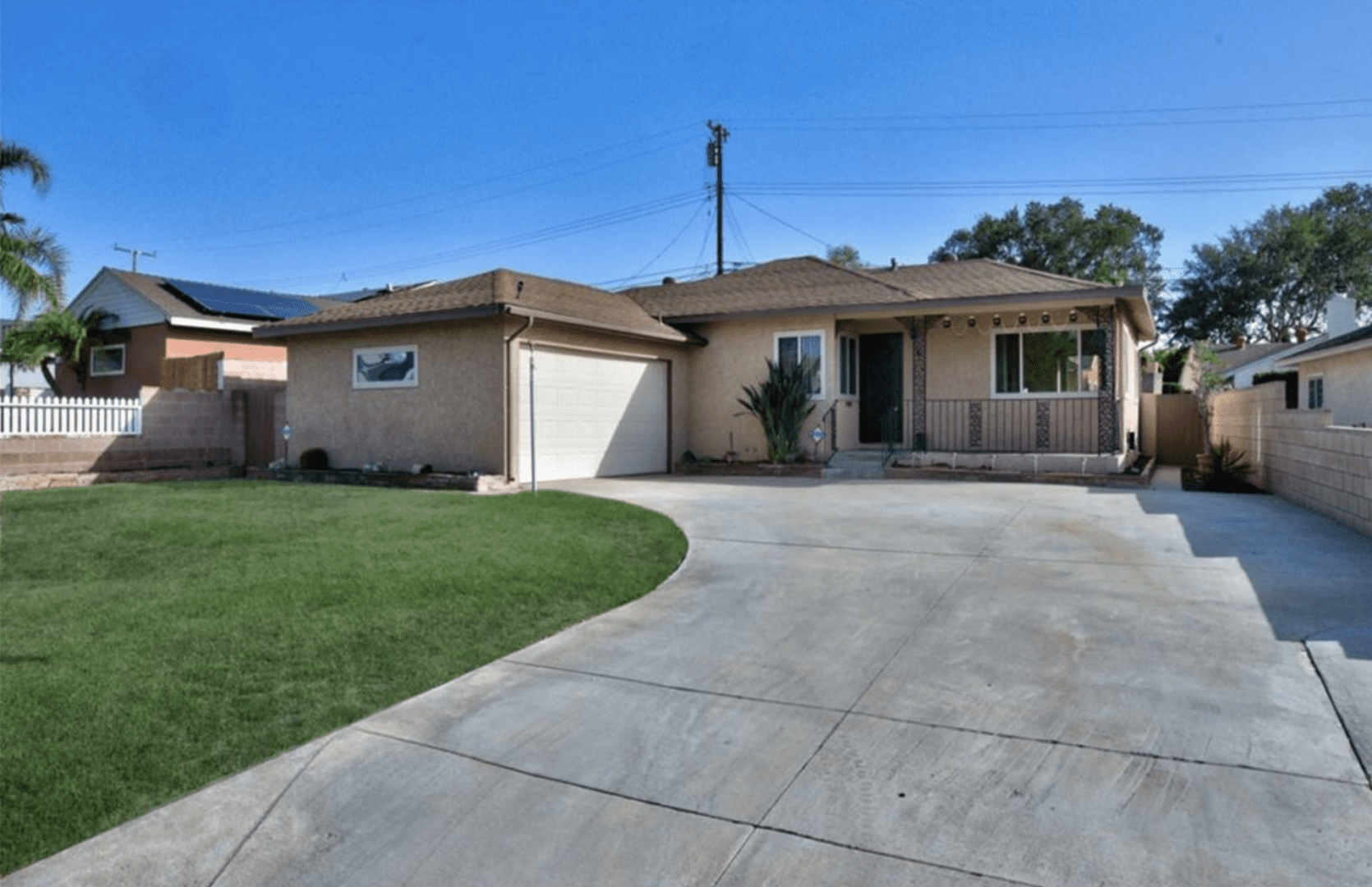 Single-story house with a curved driveway and front lawn.