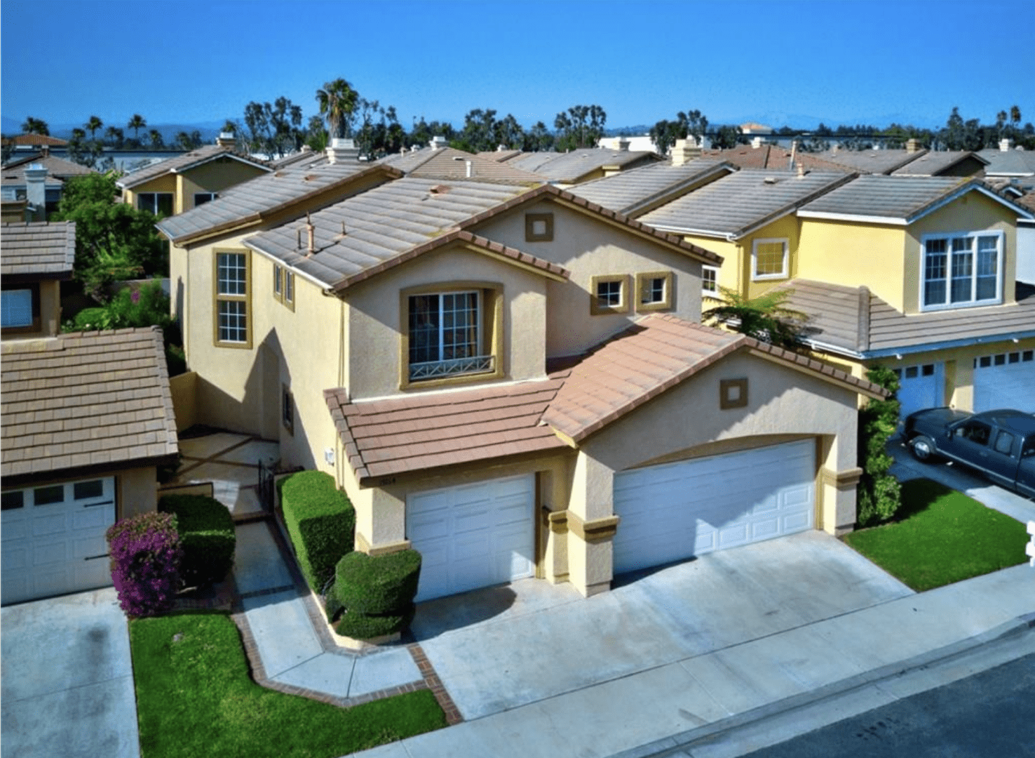 Row of suburban houses with tiled roofs on a sunny day.